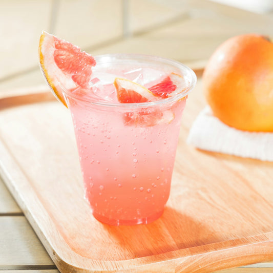 Pink grapefruit paloma over ice with a grapefruit wedge